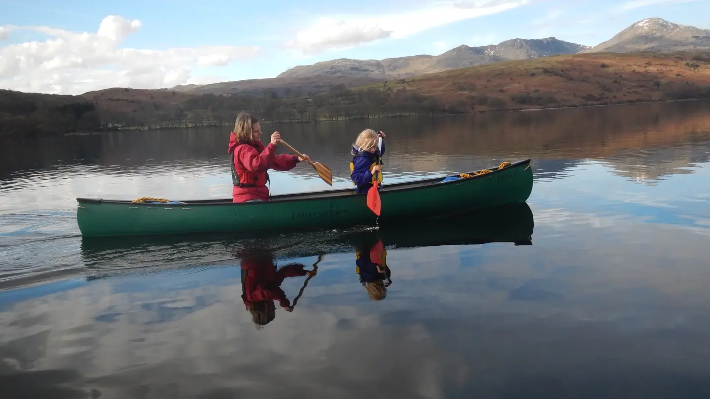 Hou 13 being paddled in tandem with a Lady and a child
